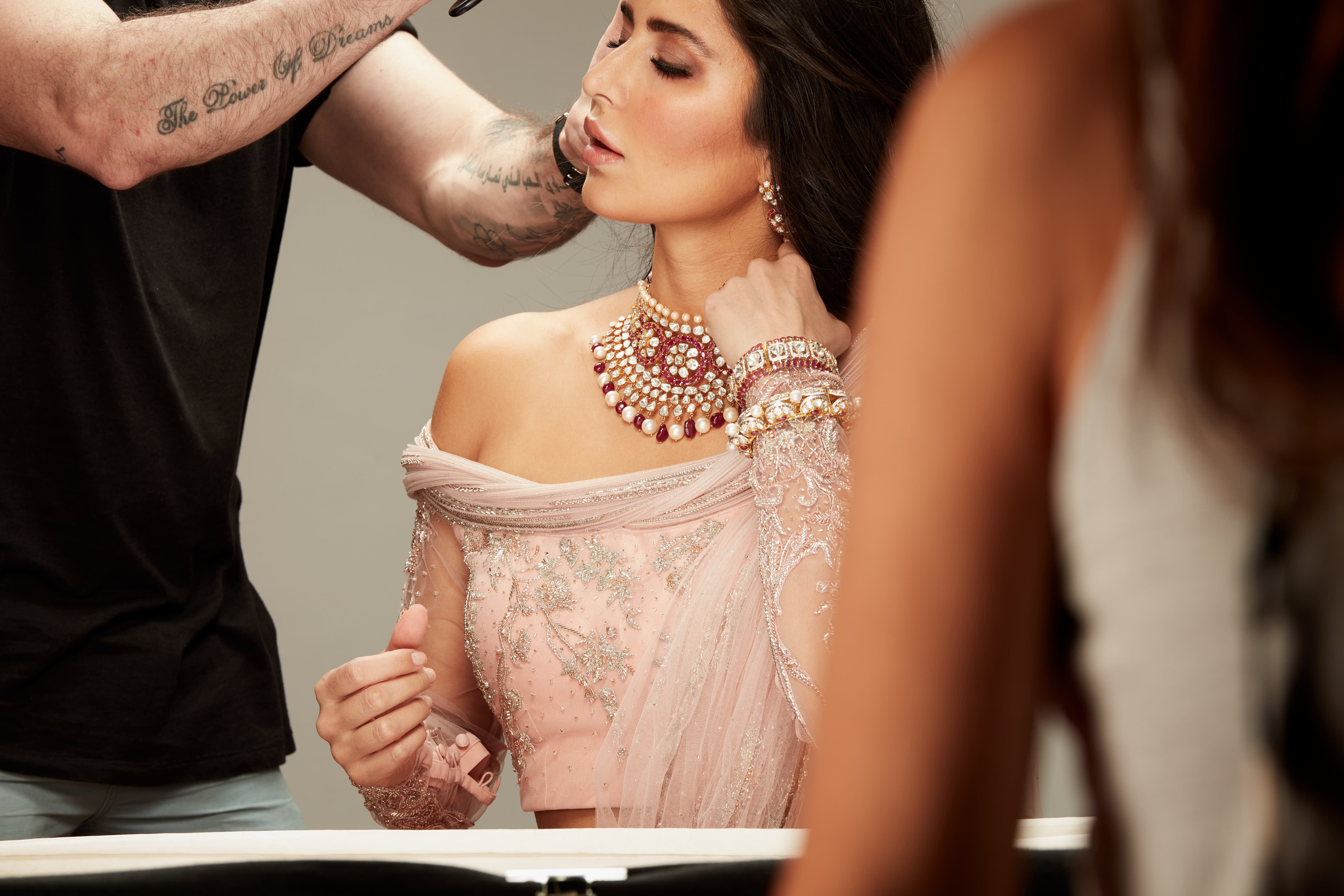 Katrina looking gorgeous with a heavy necklace adorning her neck and matching kadas, getting her makeup and hair touch up done.