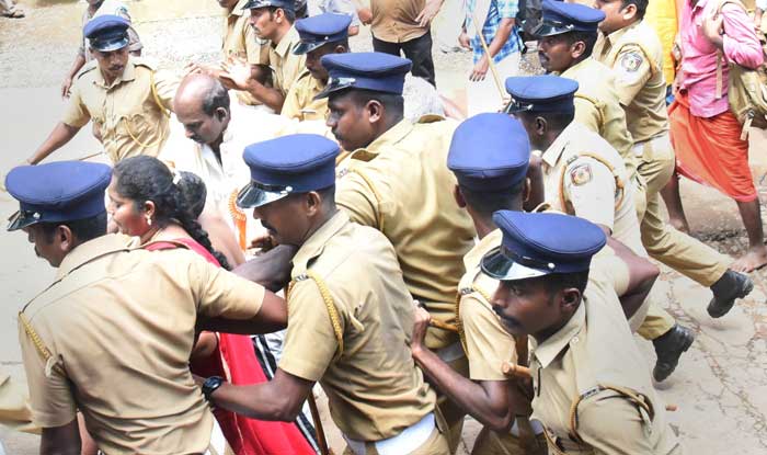 Police escort Madhavi (of Andhra Pradesh) and her family members after she was heckled by the protesters