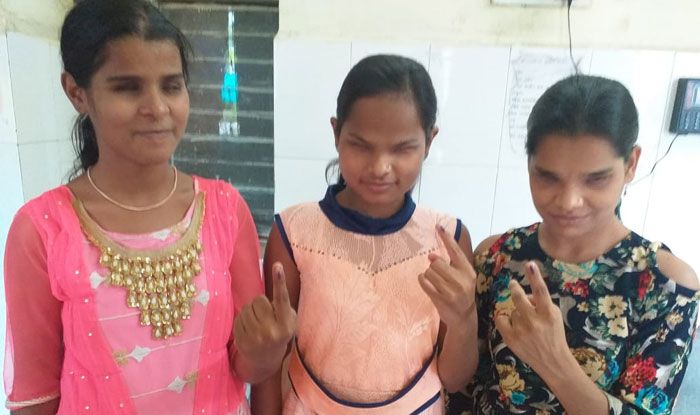 Visually challenged voters show their inked fingers