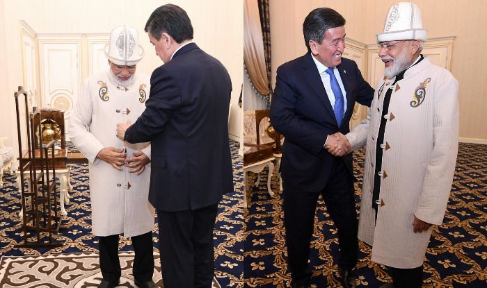 Kyrgyzstan President Jeenbekov gifts PM Modi a traditional Kyrgyz hat and coat. Photo Courtesy: IANS