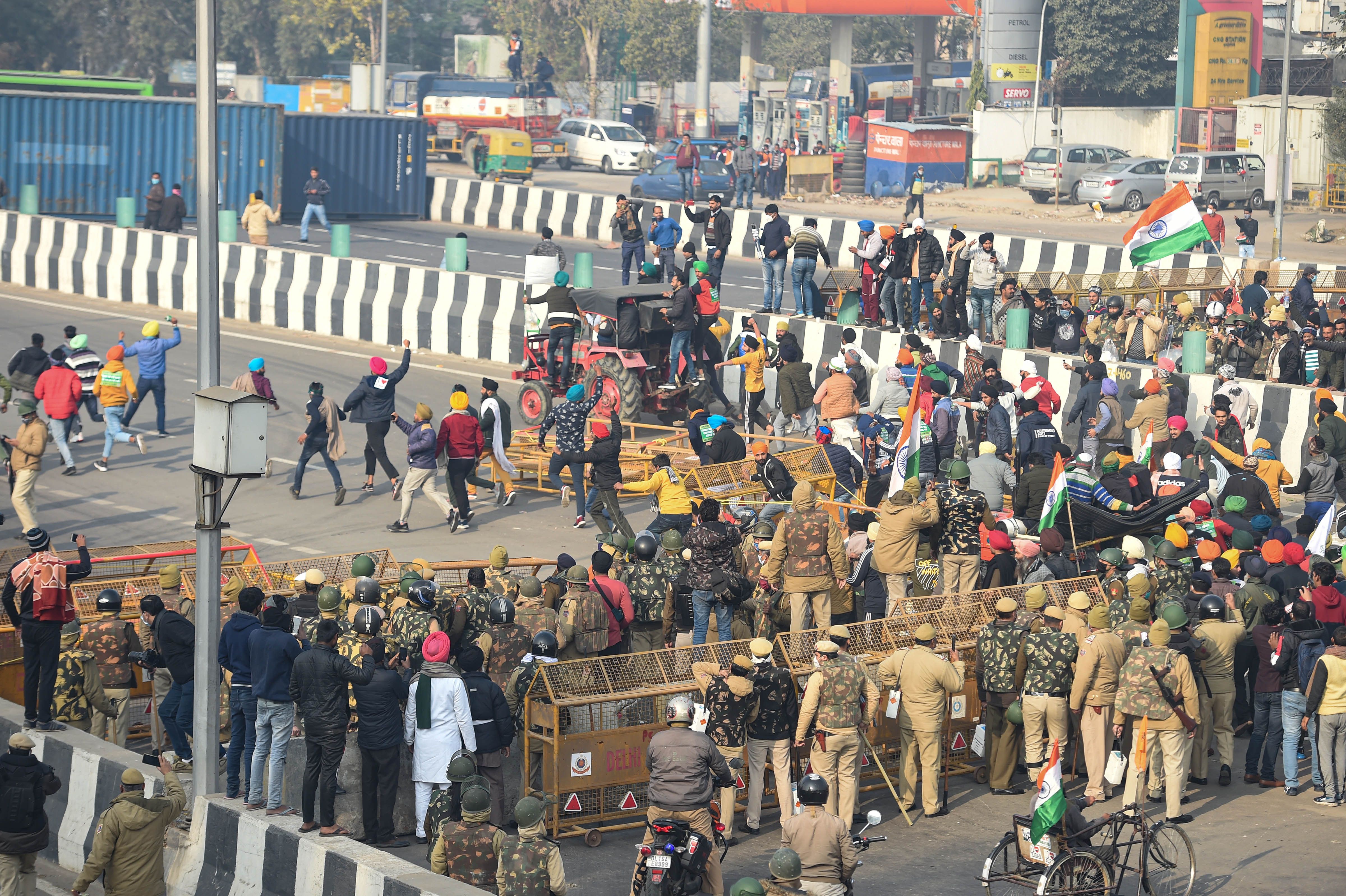 Farmers break the police barricades at the Ghazipur border as move towards Akshardham during their tractor rally on Republic Day in New Delhi, Tuesday, Jan. 26, 2021. (PTI Photo)