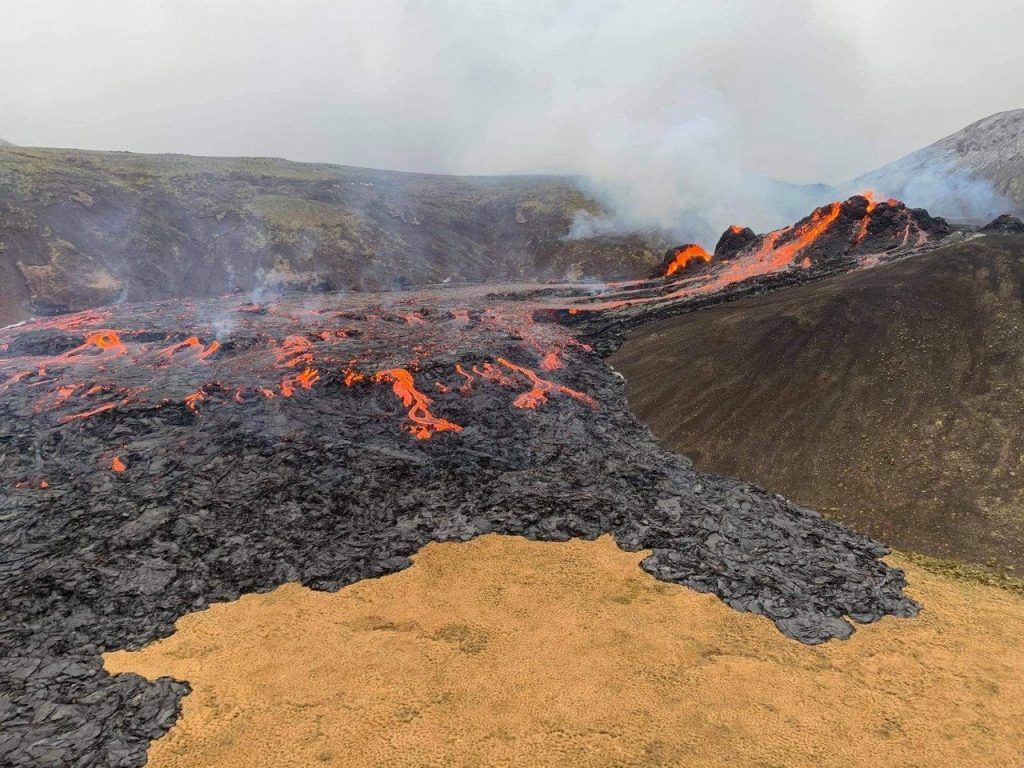 People Play Volleyball In Front Of Erupting Volcano In Iceland;