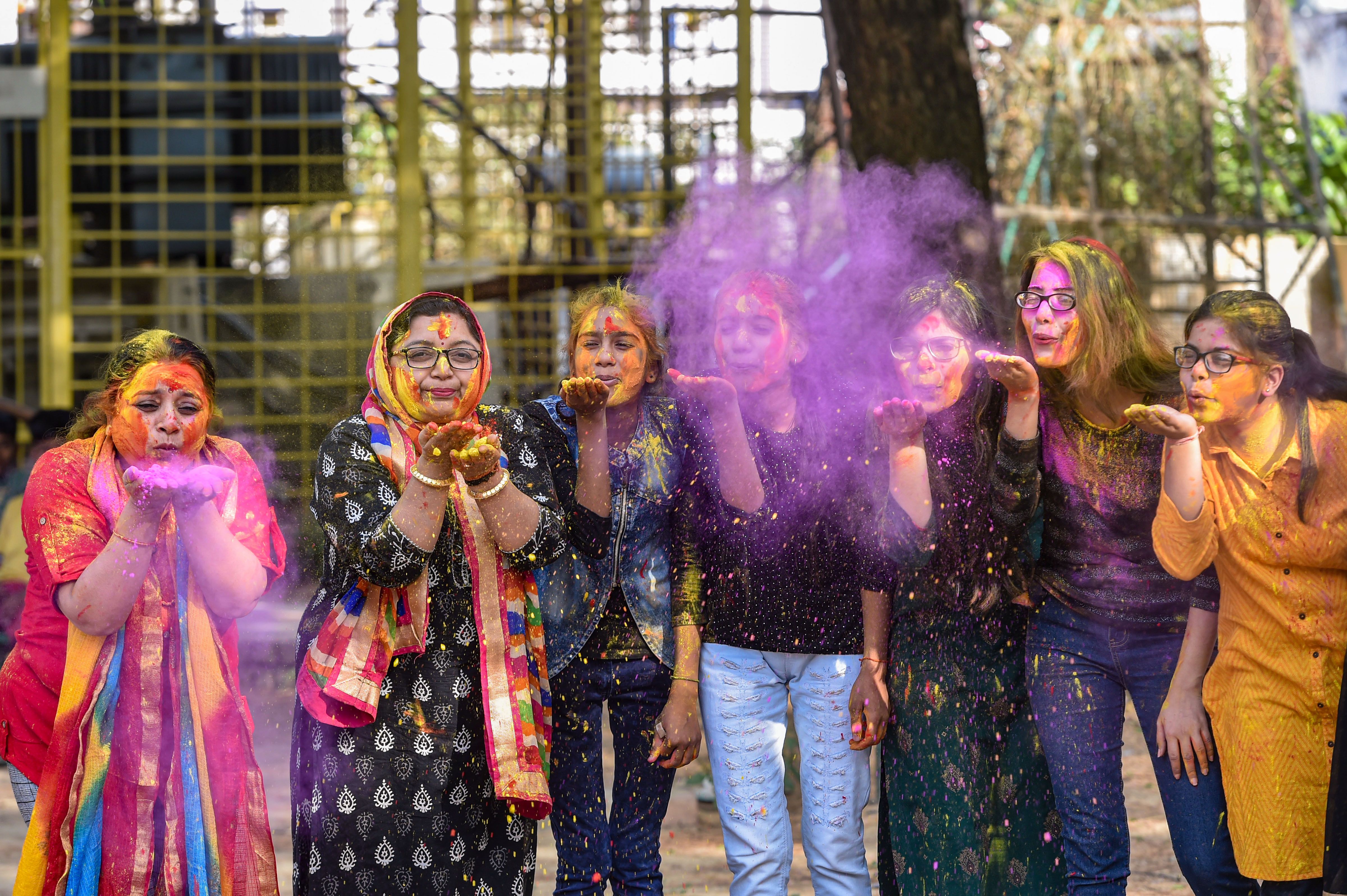 Holi 2021: Women play with colours ahead of Holi festival in Lucknow.
