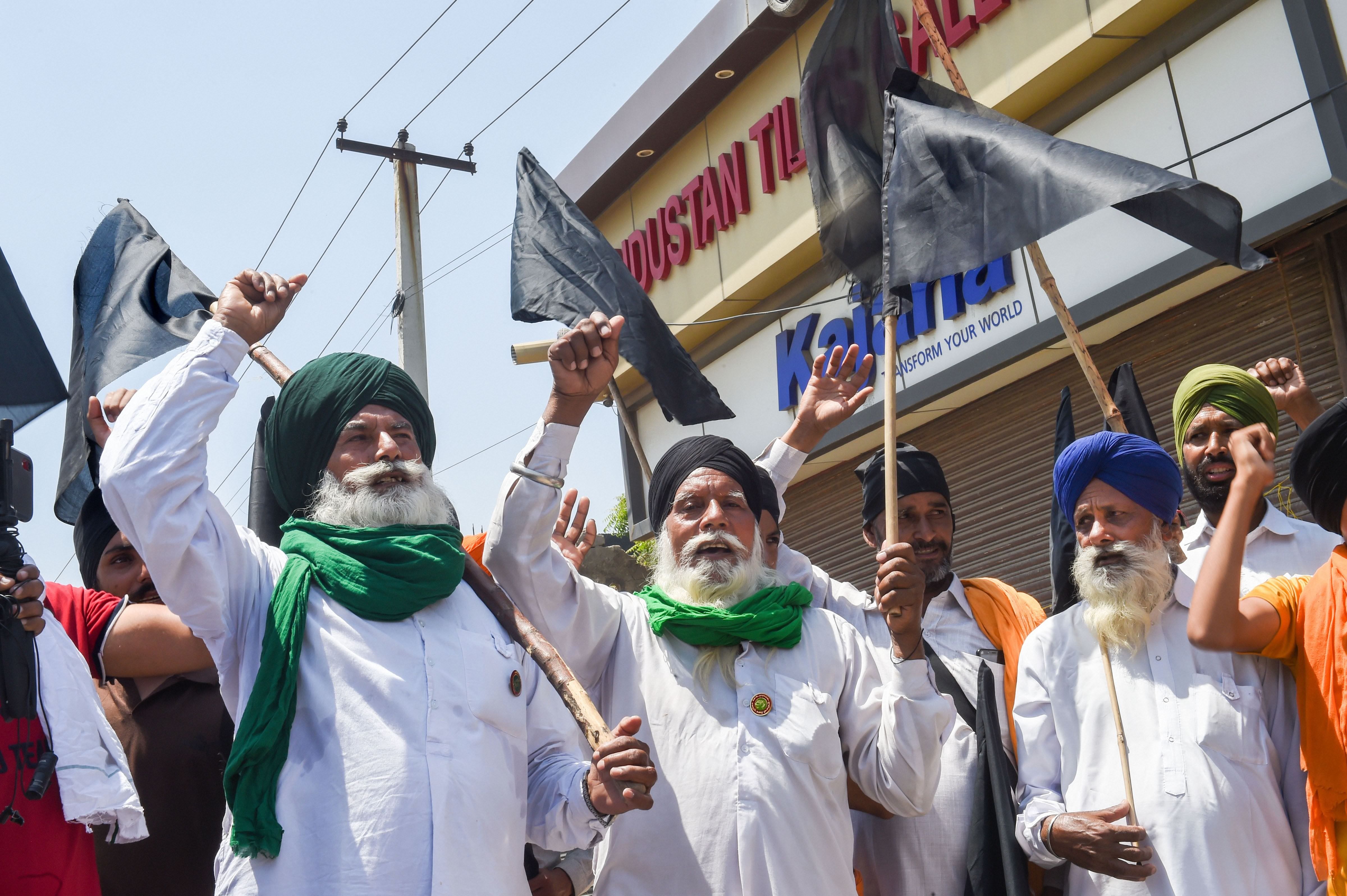 Farmers and supporters protest with black flags against farm laws marking a Black Day, at Singhu border in New Delhi, Wednesday, May 26, 2021. (PTI Photo)