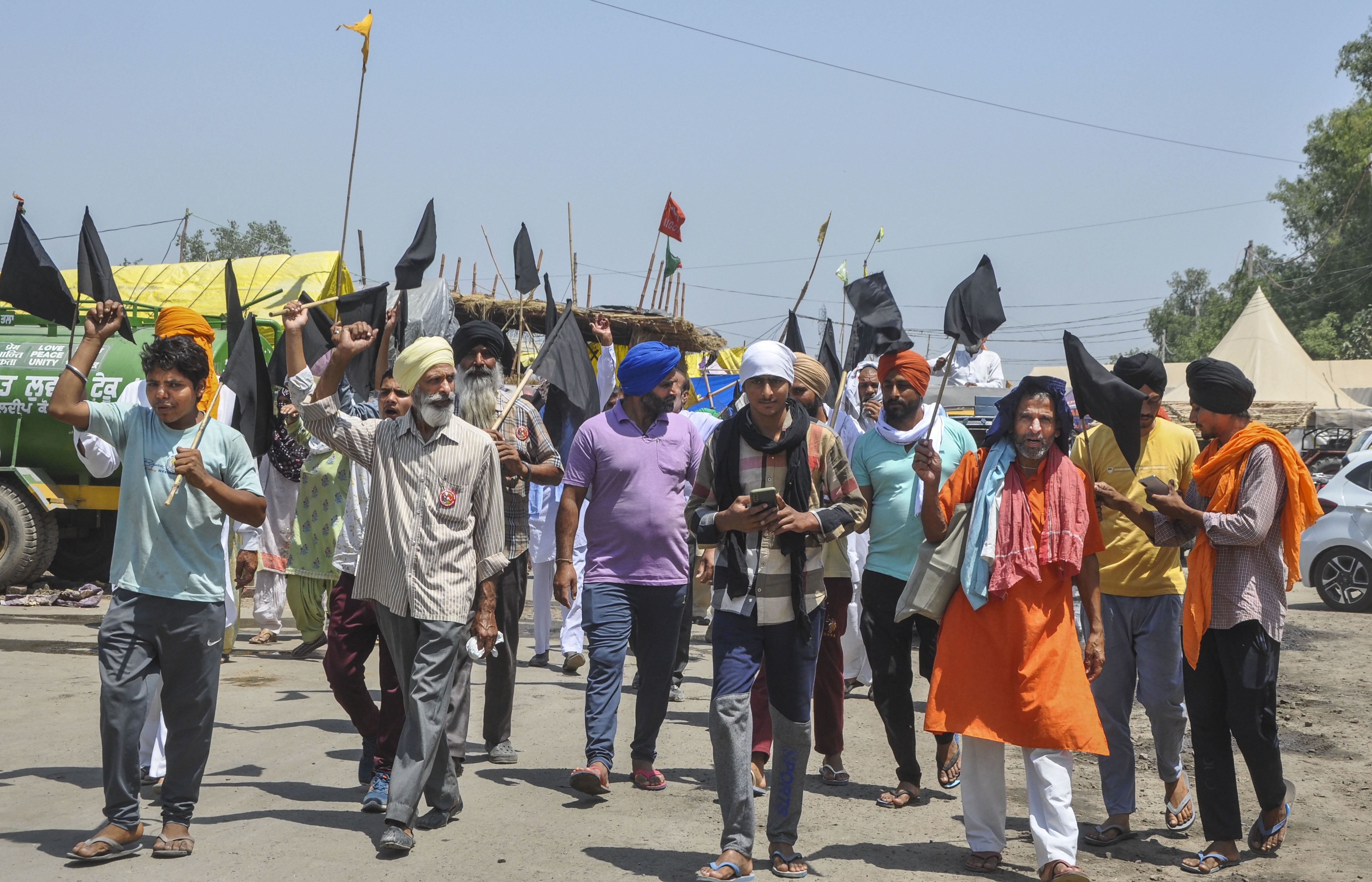 Farmers and supporters protest with black flags against farm laws marking a Black Day, at Singhu border in New Delhi, Wednesday, May 26, 2021. (PTI Photo)