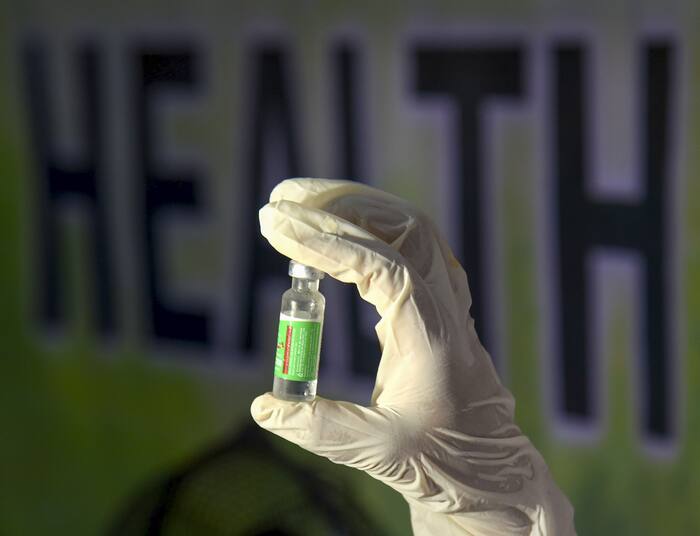 A health worker holds a vial of a booster dose of COVID-19 vaccine in Guwahati, Monday, Jan. 10, 2022. PTI