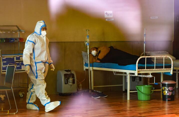 A health worker walks inside the Shehnai Banquet Hall, a COVID-19 care facility, during the third wave in New Delhi, Monday, Jan. 10, 2022. (PTI Photo)
