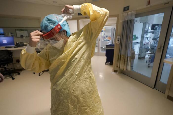 Registered nurse Sara Nystrom, of Townshend, Vt., prepares to enter a patient's room in the COVID-19 Intensive Care Unit at Dartmouth-Hitchcock Medical Center, in Lebanon, N.H., Jan. 3, 2022. (AP Photo)