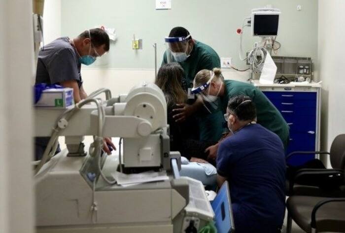 Healthcare workers help a patient in the