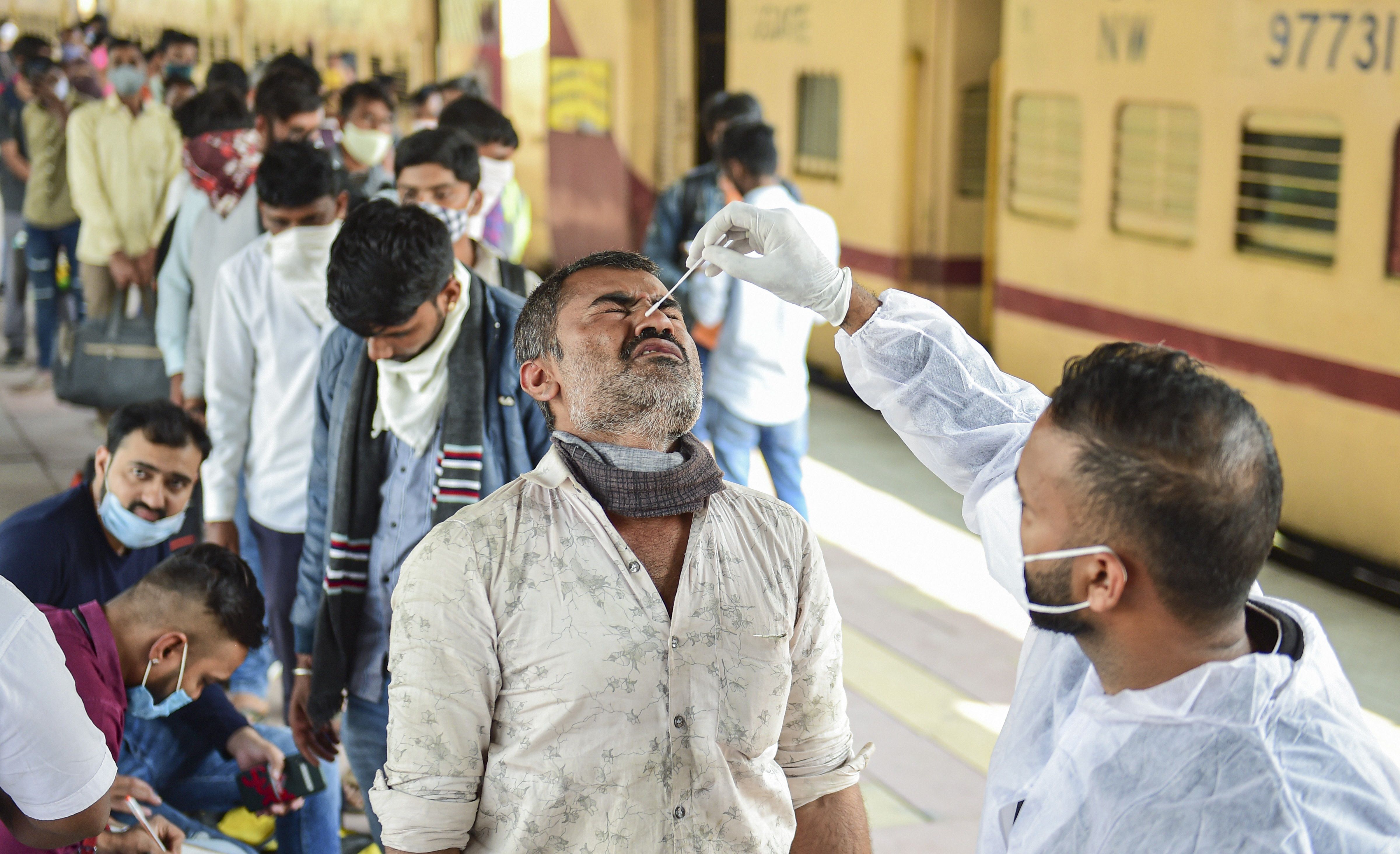 A BMC health worker collects swab sample of an outstation passenger for COVID-19 test, at Dadar railway station in Mumbai, Wednesday, Jan. 4, 2022. (PTI Photo