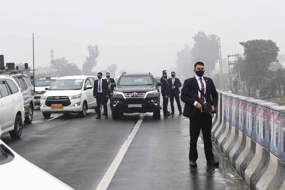 Security personnel surround the official vehicle of Indian Prime