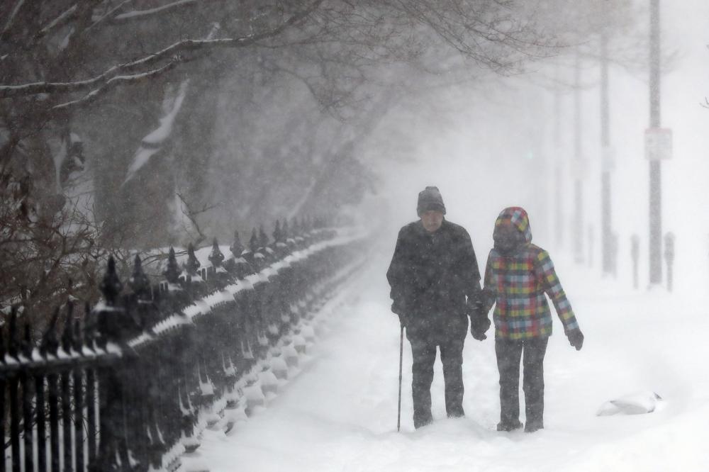 A couple walks through snow on Beacon Street past the Public Garden, Saturday, Jan. 29, 2022, in Boston. (AP Photo/Michael Dwyer)A couple walks through snow on Beacon Street past the Public Garden, Saturday, Jan. 29, 2022, in Boston. (AP Photo/Michael Dwyer)