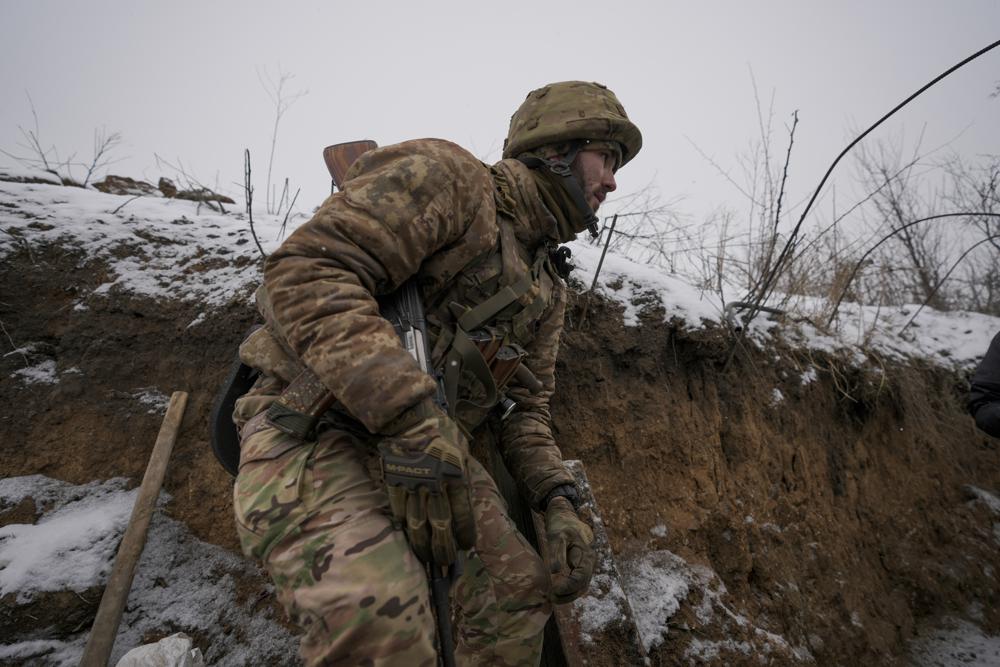 A Ukrainian serviceman ducks in a trench on the front line in the Luhansk region, eastern Ukraine, Friday, Jan. 28, 2022. High-stakes diplomacy continued on Friday in a bid to avert a war in Eastern Europe. The urgent efforts come as 100,000 Russian troops are massed near Ukraine's border and the Biden administration worries that Russian President Vladimir Putin will mount some sort of invasion within weeks. (AP Photo/Vadim Ghirda)