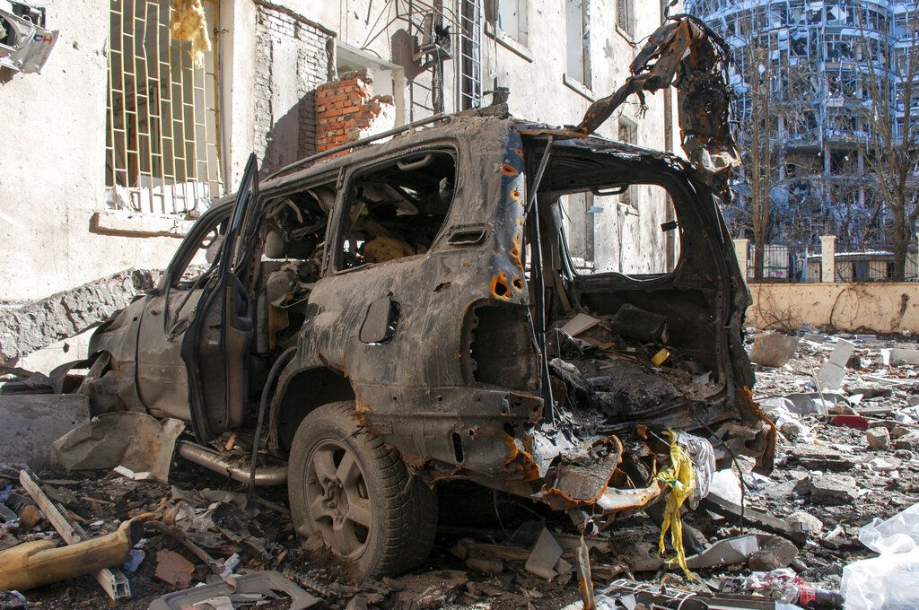 A car destroyed by shelling is seen in a street in Kharkiv, Ukraine, Tuesday, March 22, 2022. (AP Photo/Andrew Marienko)