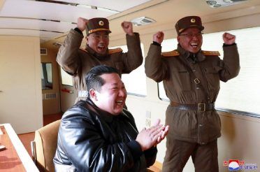 (In this photo distributed by the North Korean government, North Korean leader Kim Jong Un, front, claps during a test-fire of what it says a Hwasong-17 intercontinental ballistic missile (ICBM), at an undisclosed location in North Korea on March 24, 2022.)