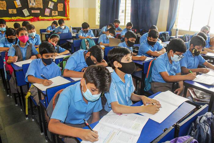 Students wearing face masks attend a class at a school. (PTI photo)