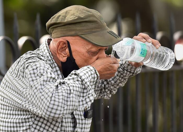 A pedestrian quenches his thirst on a hot summer day, at Cannaught Place in New Delhi, Sunday, April 24, 2022. (PTI Photo)