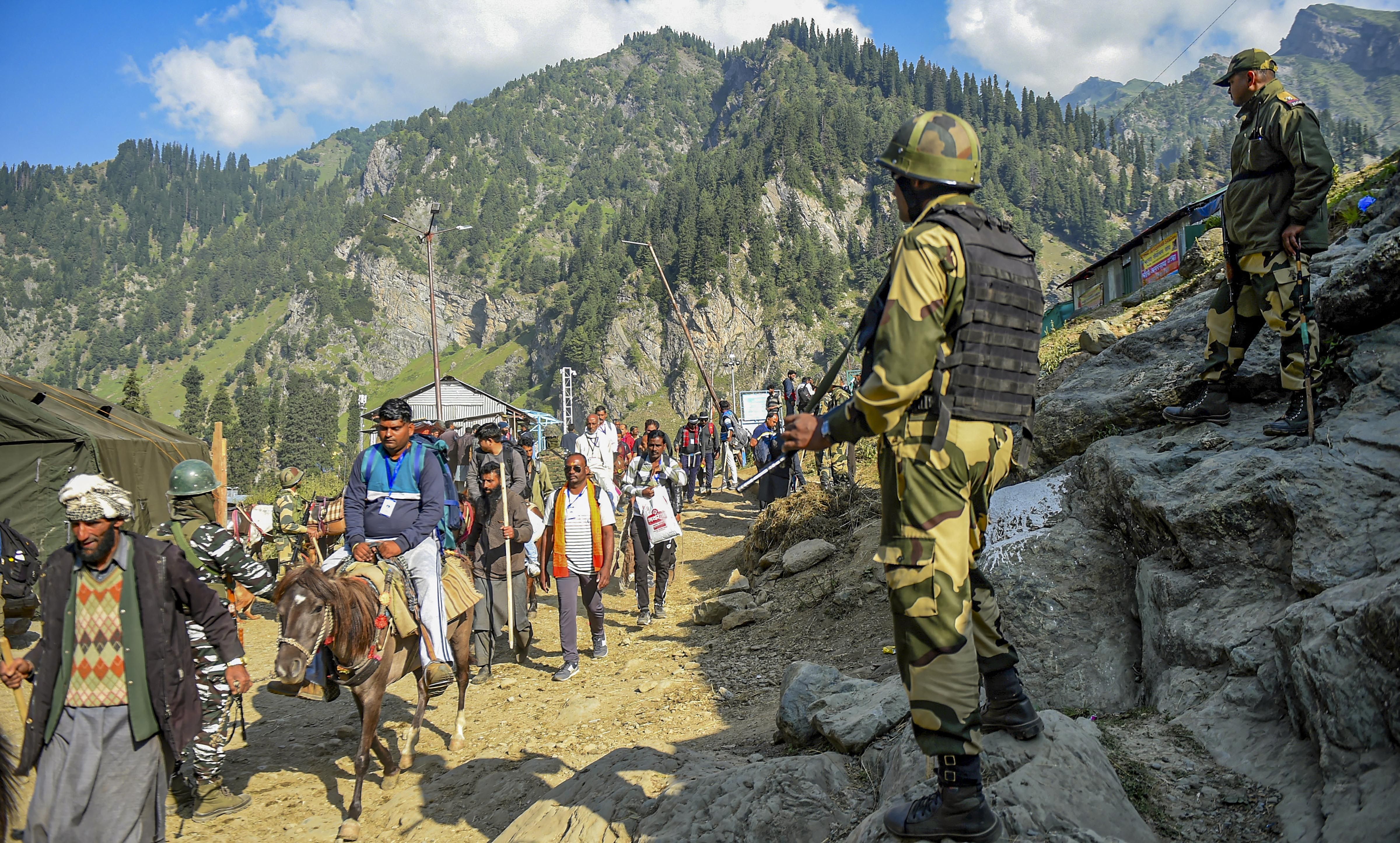 Security personnel stands guard as pilgrims proceed for the cave shrine of Amarnath, at Chandanwari in Anantnag district of south Kashmir, Thursday, June 30, 2022. The 43-day long yatra began Thursday after a gap of over two years due to COVID-19. (PTI Photo