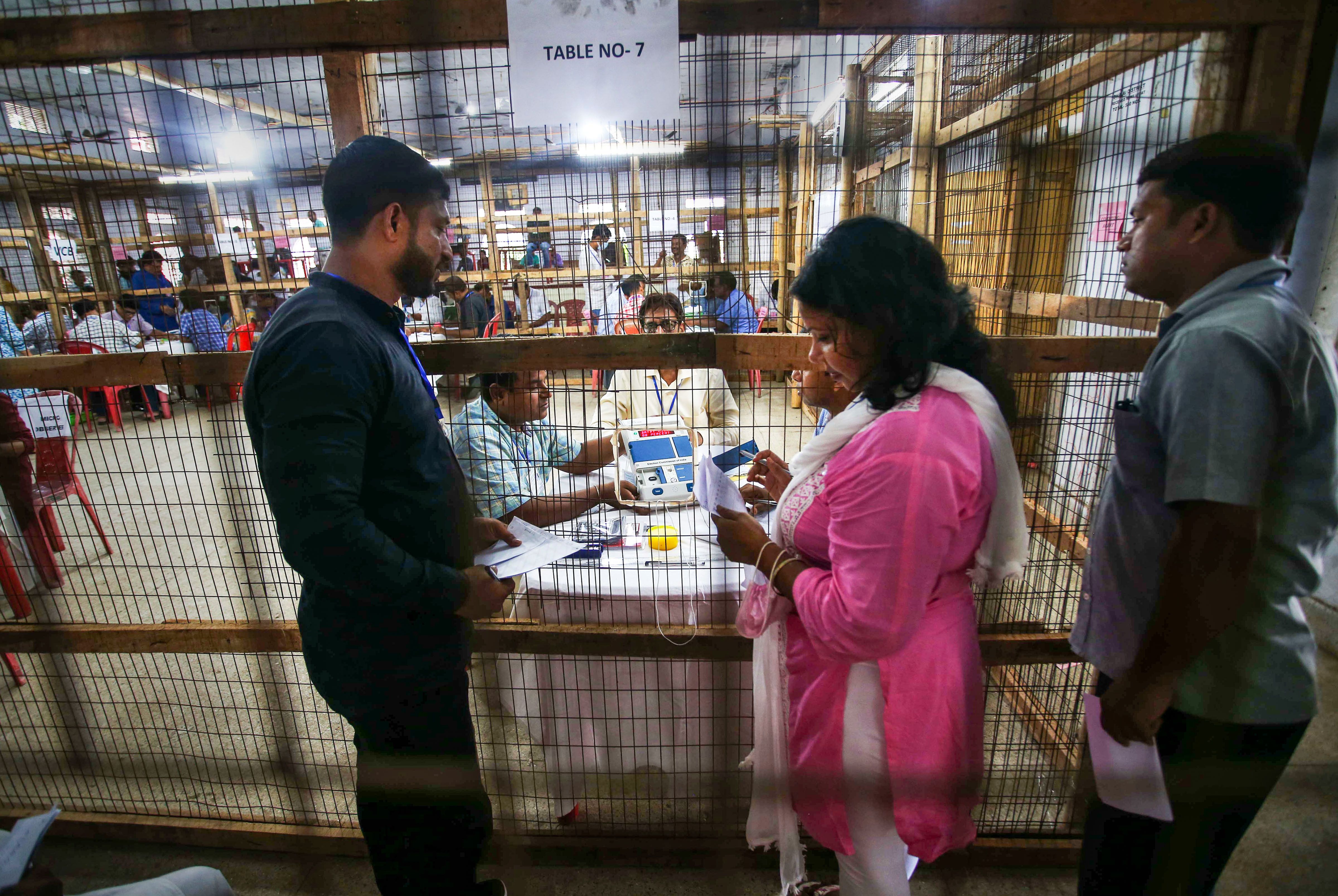 Election staff members with an Electronic Voting Machine (EVM) during the counting of votes of the Tripura Assembly by-elections, at a counting centre in Agartala, Sunday, June 26, 2022. (PTI Photo)