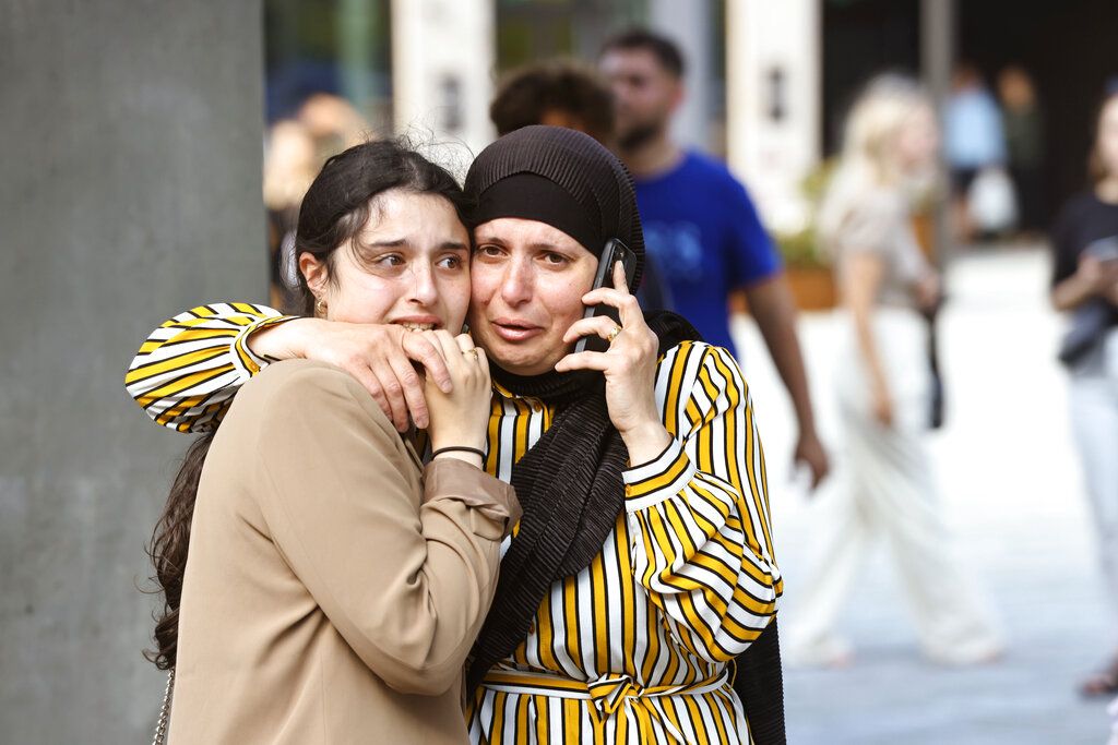 People evacuated from the Fields shopping center react, in Orestad, Copenhagen, Denmark, Sunday, July 3, 2022, after reports of shots fired. Danish police say several people have been shot at a Copenhagen shopping mall. Copenhagen police said that one person has been arrested in connection with the shooting at the Field’s shopping mall on Sunday. Police tweeted that several people have been hit but gave no other details. (Olafur Steinar Gestsson /Ritzau Scanpix via AP)