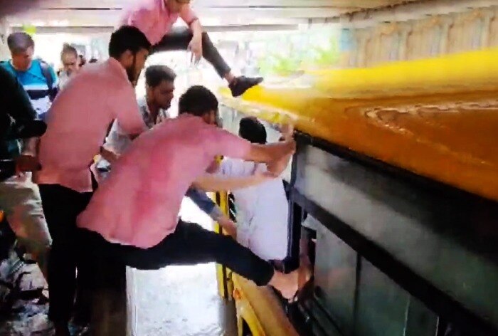 Locals rescue students from a stranded bus in Nadiad amid heavy rain and waterlogging