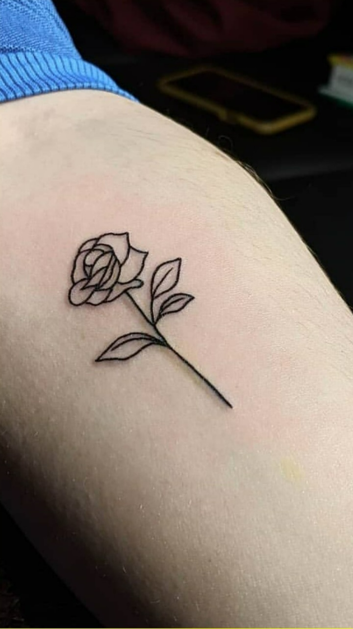 Tiny rose tattoo on the back of the neck.