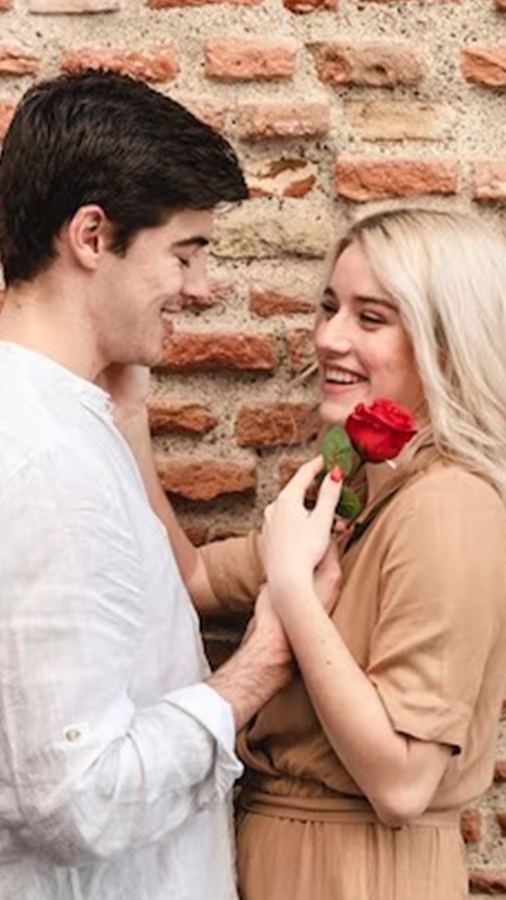 Man presents a surprise bunch of roses to a woman at the front door of her  home Stock Photo - Alamy