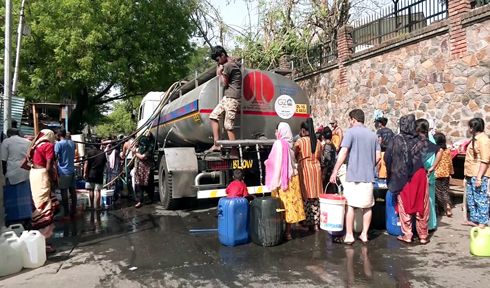 People gather to collect drinking water from a tanker as they face water scarcity in Delhi. Photo: ANI